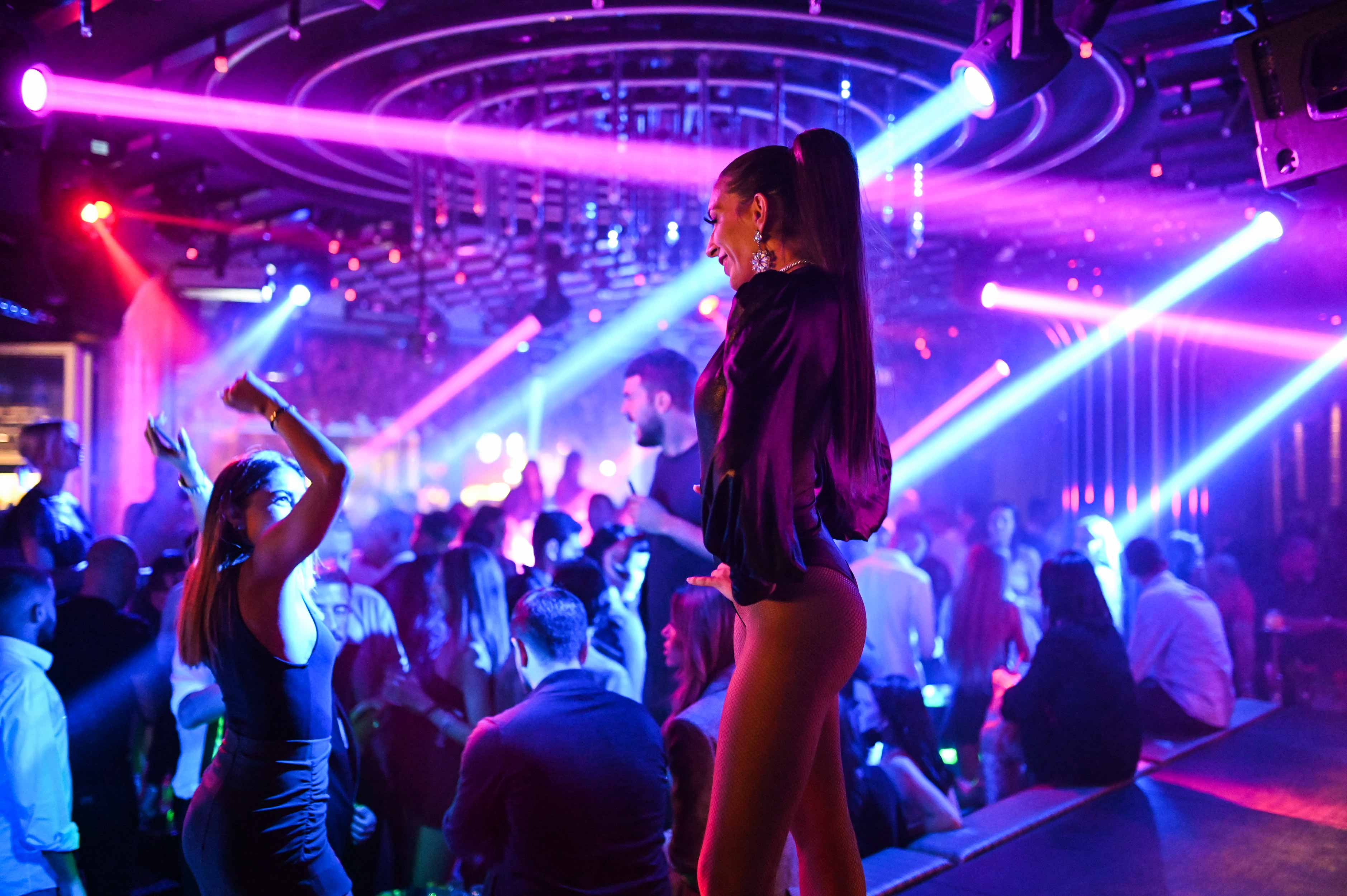 Glamourous woman standing in front of club dancefloor